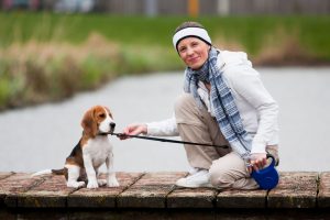 frau mit beagle an flexi leine am see