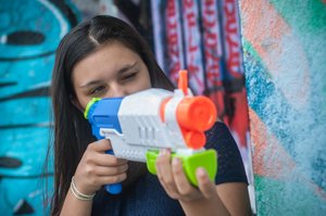 mädchen nutzt wasserpistole zur taubenabwehr